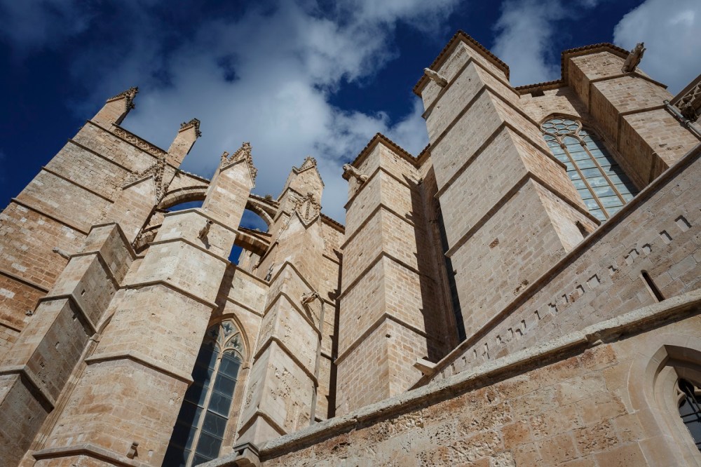 You see a part of the cathedral in Palma de Mallorca in front of the blue sky.